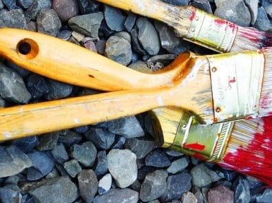 three paint brushes with red paint on them