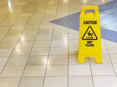 a tile floor with a Caution Wet Floor sign