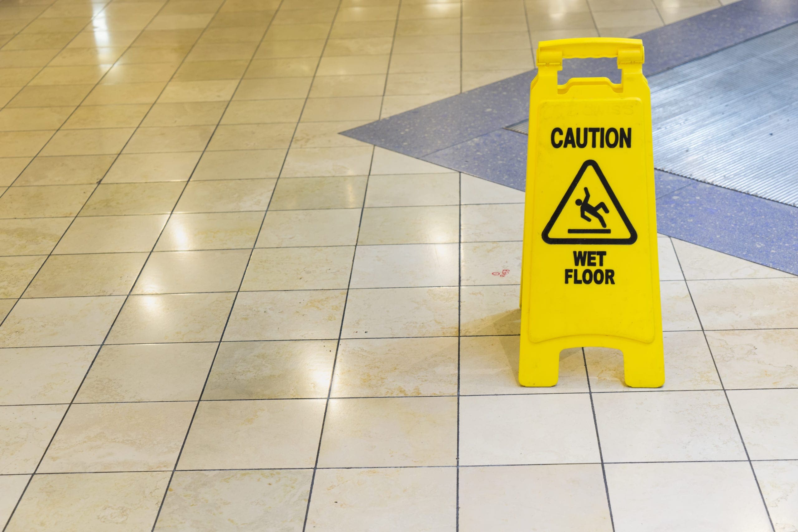 a tile floor with a Caution Wet Floor sign