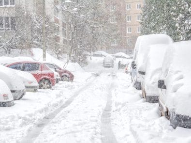 cars parked on the street covered in snow