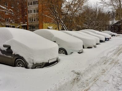 cars covered in snow in a parking lot