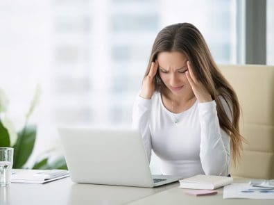 a woman with a headache holding her temples