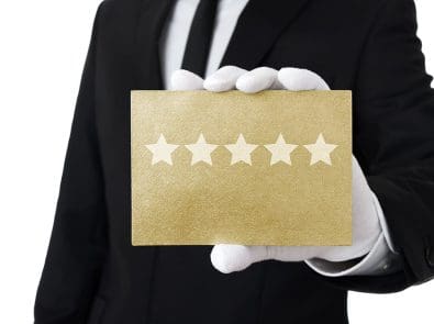 a man with white gloves holding a card with five stars on it