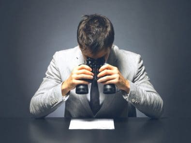 a businessman looking at a contract with binoculars