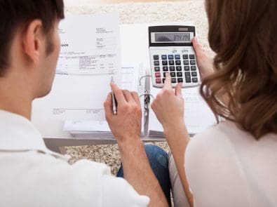 a couple reviewing an invoice with a calculator